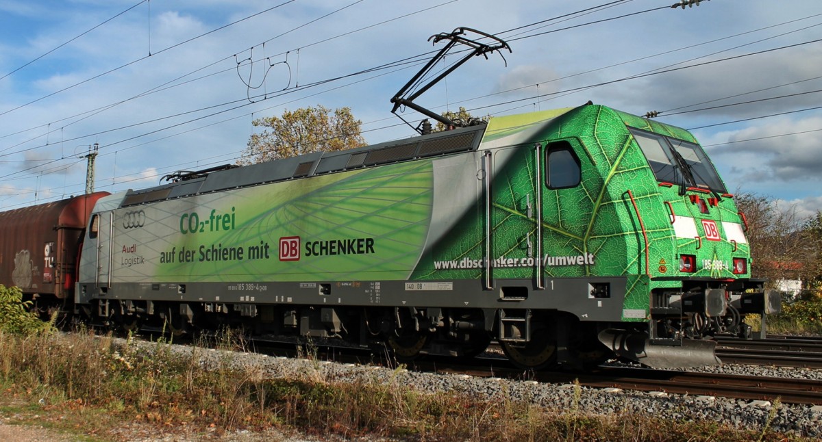 Lokportrait von 185 389-4 (DB Schenker/Audi CO2 frei), als sie am 09.11.2013 mit einem gemischten Gterzug vom berholgleis in Mllheim (Baden) gen Basel ausfhrt.