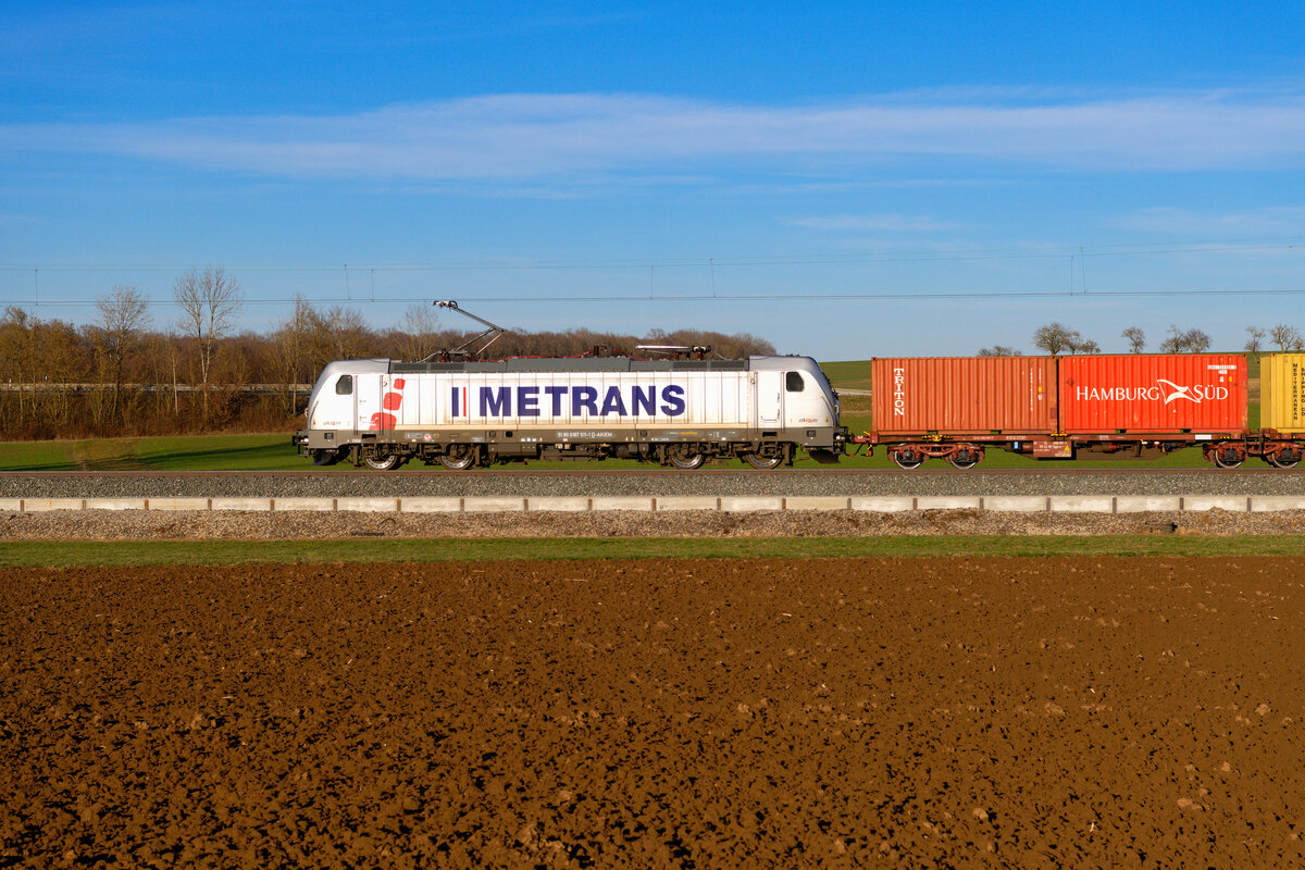Lokportrait von 187 511 Akiem/Metrans mit einem Containerzug bei Uffenheim Richtung Würzburg, 06.03.2021
