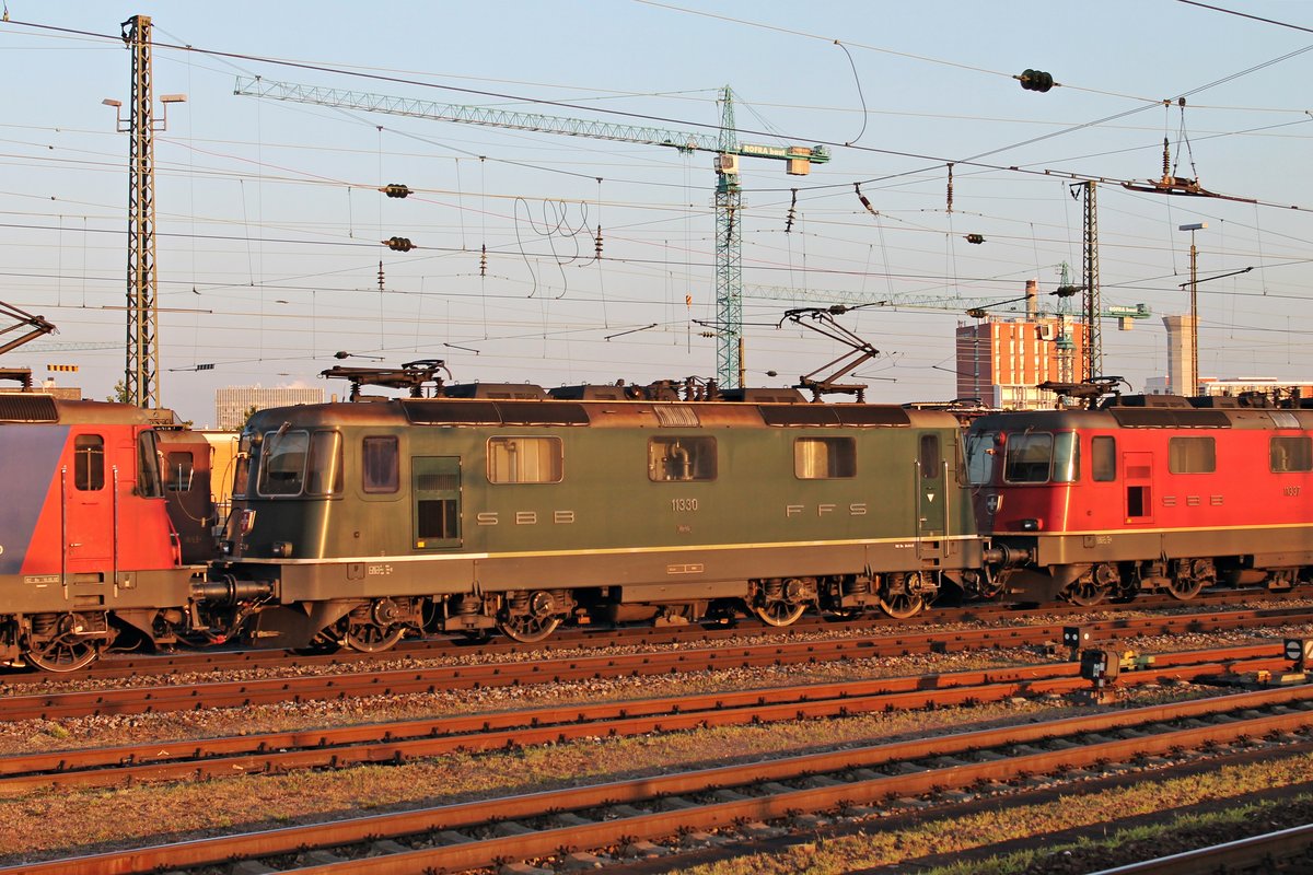 Lokportrait von der grünen Re 4/4 11330, welche am frühen Morgen des 16.07.2015 in den ersten Sonnenstrahlen zusammen mit Re 4/4 11337 und Re 421 374-0 die RoLa (Novara - Basel Bad Rbf) bespannte und durch Basel Bad Bf in Richtung Zielbahnhof fuhren.