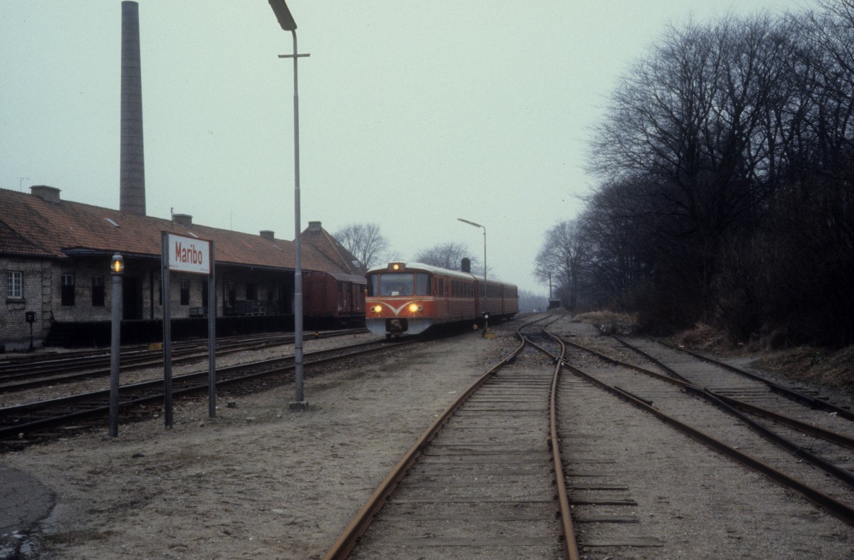 Lollandsbanen (LJ) Bahnhof Maribo: Ein Triebzug bestehend aus einem Triebwagen (Ym), einem Mittelwagen (Yp) und einem Steuerwagen (Ys) kommt am 16. februar 1982 in Maribo an. - Die dänischen Privatbahnen Lollandsbanen, GDS und HFHJ bekamen ihre ersten Y-Züge, die von der Waggonfabrik Uerdingen AG gebaut worden waren, im Jahre 1965. - Später kauften auch andere Privatbahnen Züge dieser Bauart. - Ab 1983 wurde eine neue Serie, die die Firmen DUEWAG und Scandia (in Randers) bauten, an die Bahnen geliefert. - Bei allen Privatbahnen hiessen die Triebwagen Ym, die Mittelwagen Yp und die Steuerwagen Ys. - Züge dieser Bauart fahren nur noch auf der Lemvigbanen (Vemb-Lemvig-Thyborøn-Jernbane). 