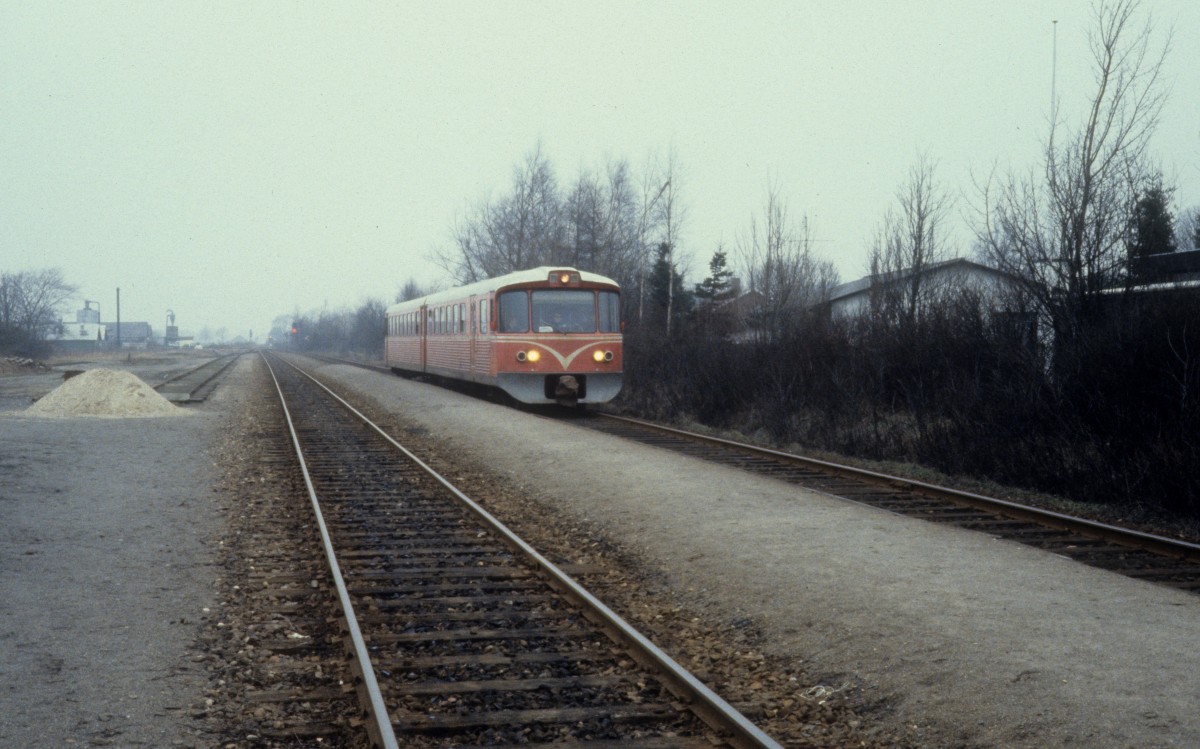 Lollandsbanen (LJ): Ein Triebzug (Ym+Ys) erreicht am 16. Februar 1982 den kleinen Bahnhof Søllested.