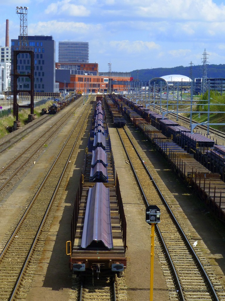 Luxembourg, Belval, verschiedene Stahlprofile warten auf den Abtransport per Bahn bei Arcelor-Mittel in Belval. Im Hintergrund rechts, der neue Bahnhof von Belval-Université. 14.04.2014