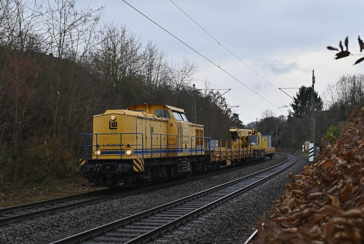 LW 203 001 alisas 203 231 mit einem Kran und zwei Flachwagen am Haken kommt am 29.11.2021 gen Zwingenberg bei Neckargerach vors Objektiv und wird verewigt.