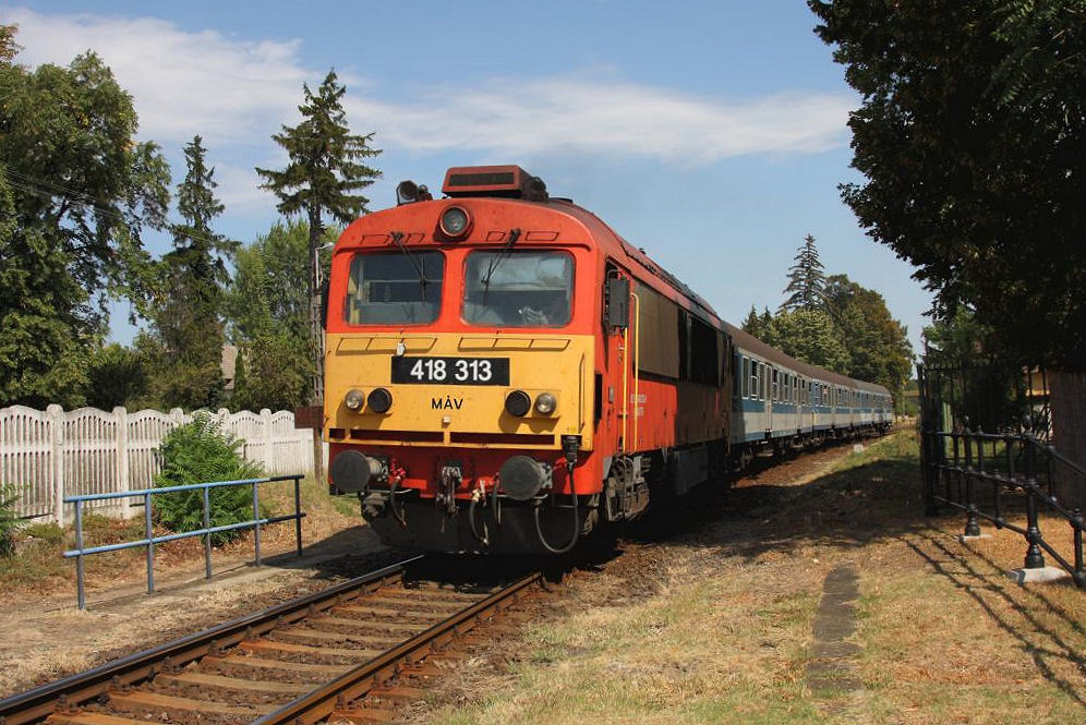 M 418313 ist am 30.08.2012 mit ihrem Personenzug aus Budapest in Revfülöp am Balaton in Richtung Tapolca unterwegs.