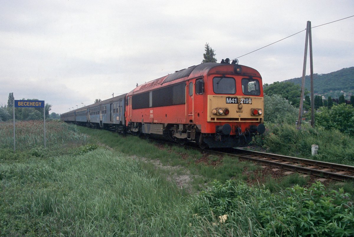 MÁV M41 2195 passiert mit einem Personenzug am 06.06.2004 die Haltestelle Becehegy in Richtung Keszthely; digitalisiertes Dia.