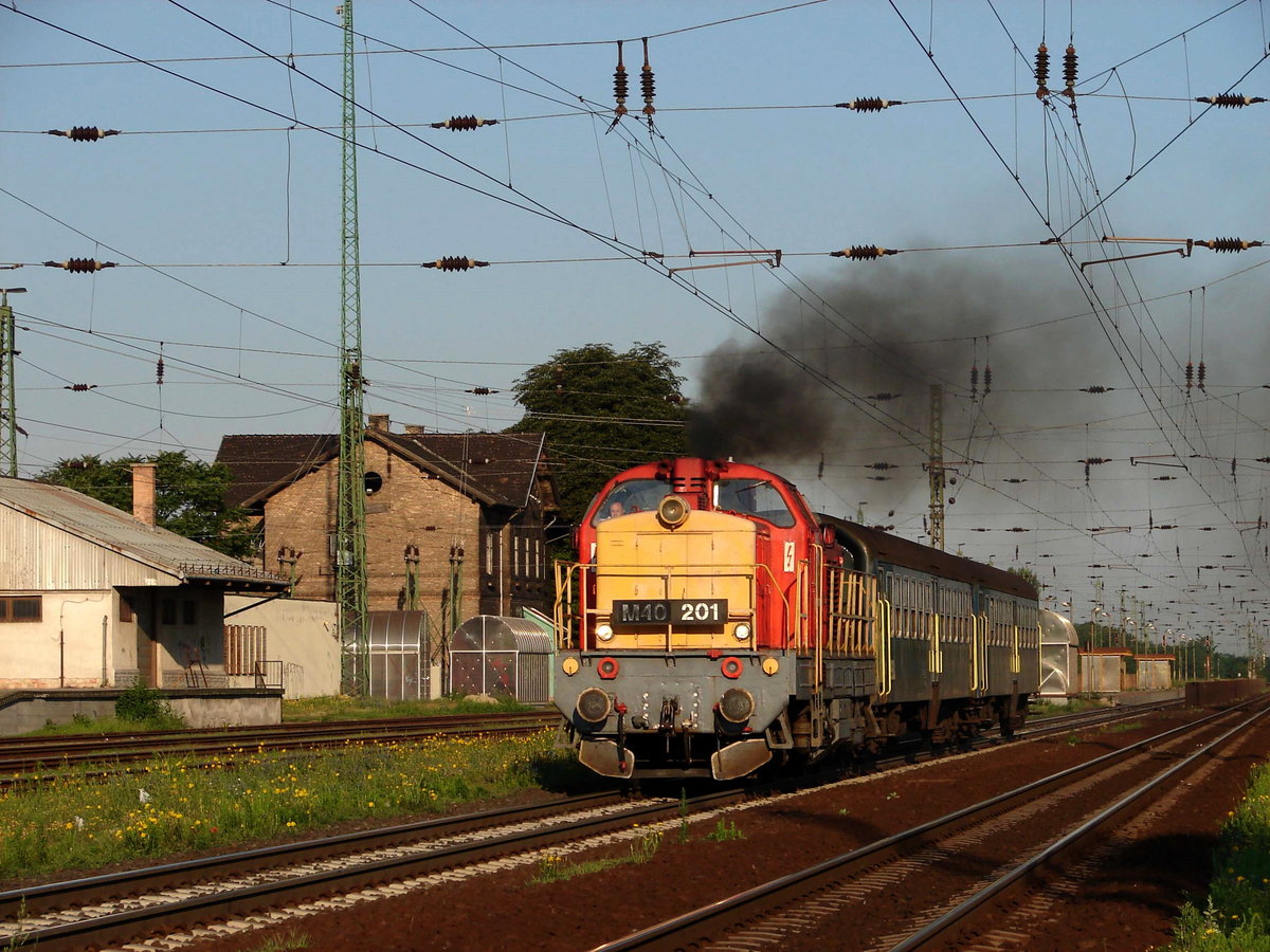 M40 201 (Altbau Diesellok von Ganz MÁVAG) mit dem Saisonzug von Győr nach Siófok bei der Abfahrt von Bahnhof Ács. 
12.07.2008.