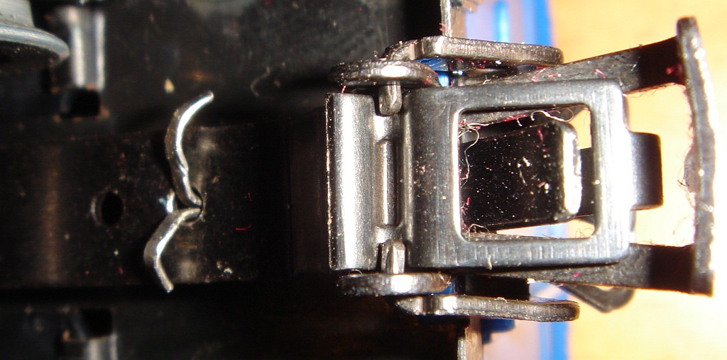 Märklin Bausatz 4937 montiert, gedeckter Güterwagen Ford, Detail: Kupplung von unten gesehen. Das Bild zeigt die Befestigung des Kupplungsbügels am Kupplungsträger mittels integraler Zapfen. Diese Methode wurde irgendwann Ende der 60er Jahre eingeführt. Vorher wurde dies bei Fertigmodellen mittels einer Art Niet  bzw. bei Bausätzen mittels eines Splints bewerkstelligt. Dass es sich bei diesem Wagen um einen Bausatz handelt, erkennt man noch an dem Splint, mit dem die gesamte Kupplung am Wagenboden befestigt ist. Bei Fertigmodellen ist das ebenfalls eine Art Niet.
Produktion des Bausatzes 1964-1972 - Aufnahme 21.12.2013