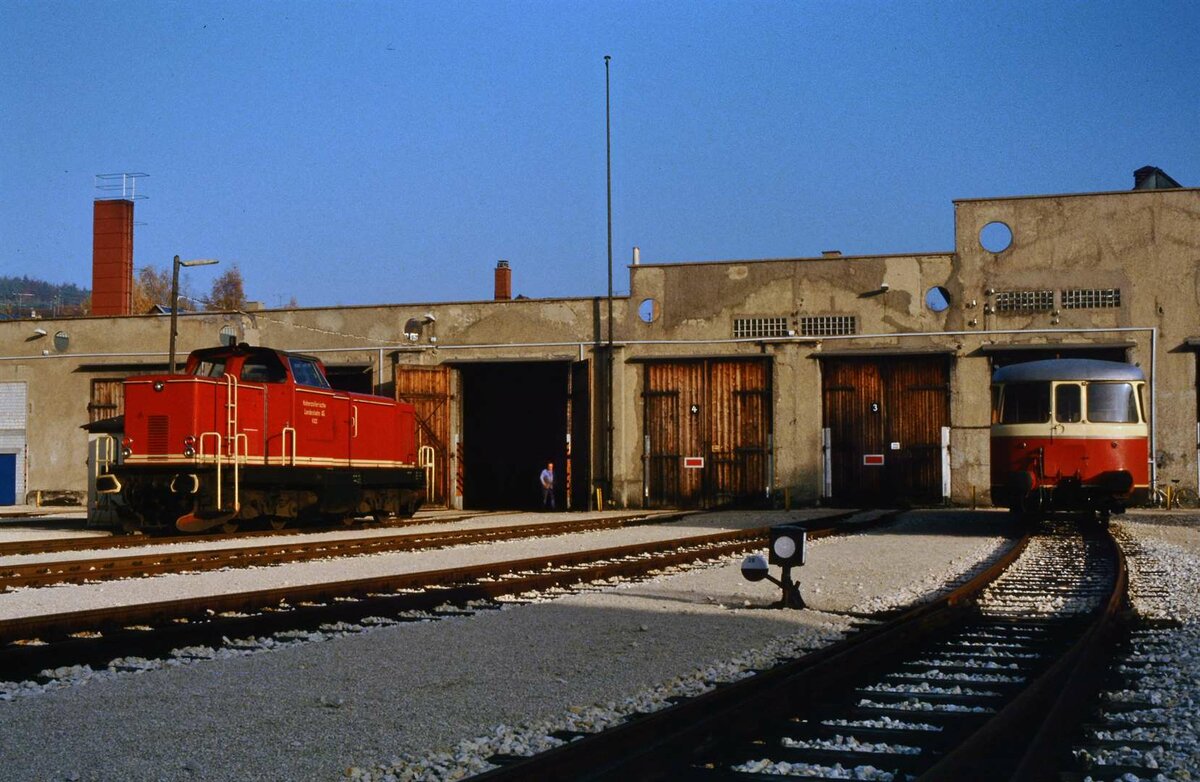 MaK-Lok V 122 und  MAN VS 14 vor dem alten Lokschuppen Gammertingen (Hohenzollerische Landesbahn). V 122 war 1963 zunächst eine Vorführlok der Maschinenbau Kiel (MaK) gewesen, bevor sie 1964 zur HzL gelangte. Schon ihre Erscheinung verwies (nicht zufällig) auf die DB-Baureihe V 100. Sie war sozusagen eine vereinfachte Privatbahnausführung der V 100 (DB).  2025 verliert sich ihre Spur, nachdem ihr bisheriger Standort, ein Heilbronner Eisenbahnmuseum, aufgelöst wurde. 
Datum: 29.10.1984