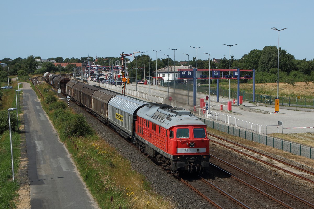 Marschbahnumleiter 2015: 232 498-6 verlässt mit dem EZ 47409 (?) den Bahnhof Niebüll. Im Hintergrund ist die Verladeanlage des SyltShuttle zu sehen. Fotografiert am 15.07.2015. 