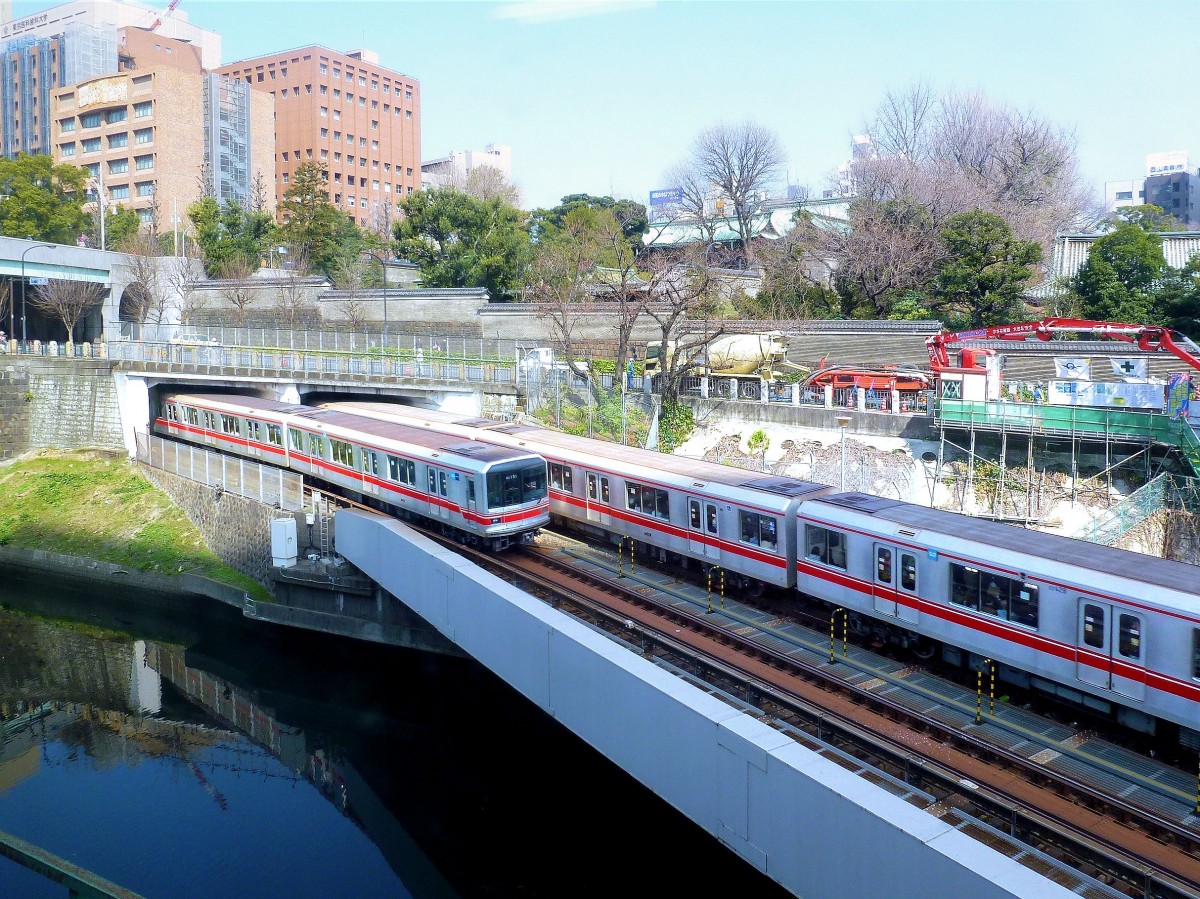 Marunouchi-Linie, Tokyo Metro: Diese Linie verläuft innerhalb von Tokyo U-förmig von Nordwesten her ins Banken-, Wirtschafts- und politische Zentrum um Tokyo Hauptbahnhof und Marunouchi, und dann wieder nach Westen hinaus. Erste Bauarbeiten erfolgten schon 1942, die Eröffnung des ersten Teilstücks war 1954. 1962 fertig erstellt. 24,2 km lang, dazu eine 3,2 km lange Zweiglinie. Spurweite 1435mm; Gleichstrom 600 V ab 3.Schiene (Stromschiene). Im Bild kreuzen sich zwei Züge der Serie 02 in Ochanomizu, 16.März 2013. 