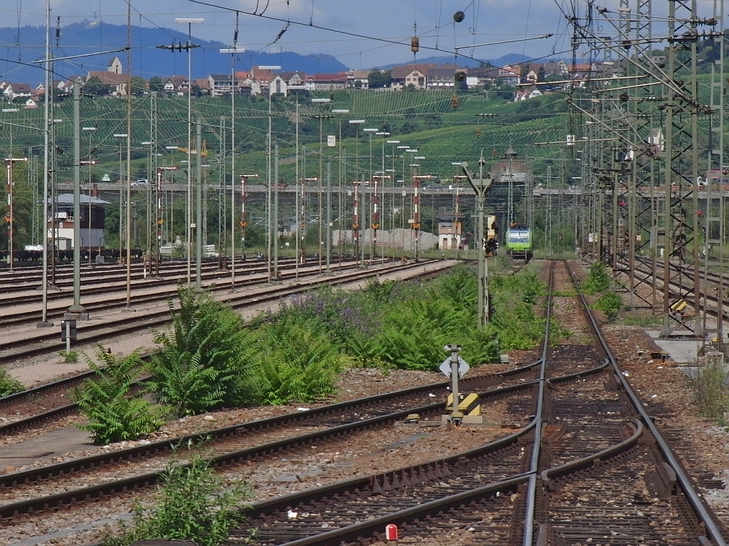 Mastengewirr und Weinberge - Blick vom Ende des zwischen Gleis 7 und 8 liegenden Bahnsteigs des Bahnhofs Weil am Rhein auf einen Teil des Gterbahnhofs und die bei Haltingen liegenden Weinberge (10.08.2013).