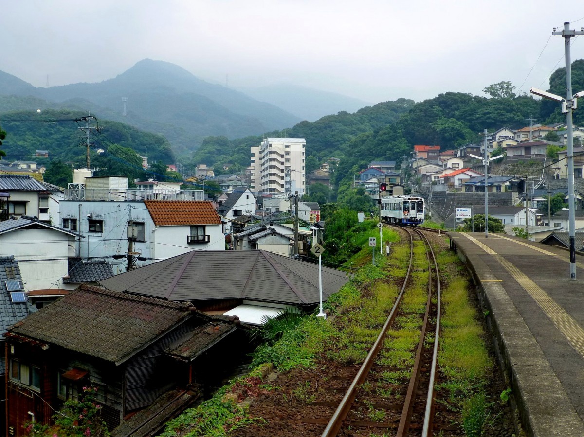 Matsu-ura-Bahn in Sasebo: Die zweitgrösste Stadt der Praefektur Nagasaki hat heute nur noch 256 000 Einwohner gegenüber 287 000 im Jahre 1970. Sasebo ist ein wichtiger Militärstützpunkt und eines der Zentren für die japanischen und amkerikanischen Flotten. Im Bild erklimmt Wagen 604 die steilen Abhänge ins Hinterland von Sasebo. 26.Juli 2013.  