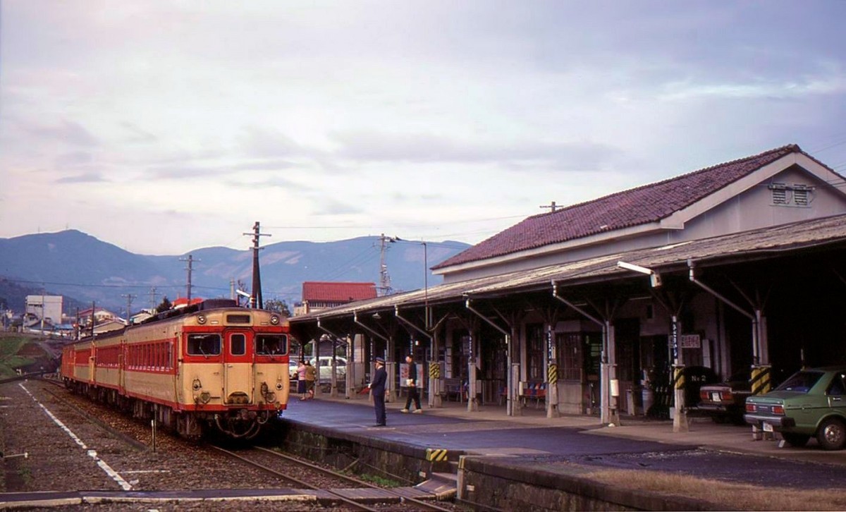 Matsuura-Bahn / KIHA 58: Die Station Hidari-ishi (ca 7 km nördlich von Sasebo): Als die Bahn noch staatlich war, herrschte erheblicher Verkehr, so dass Vierwagenzüge die Norm bildeten. In diesem Bild vom 19.März 1981 steht ein Zug mit KIHA 58 154 am Bahnhof (KIHA 58-Gruppe = total 1823 Wagen, 1961-1969 gebaut, bis 2011 ausgemustert, 29 gingen nach Sakhalin (dort wegen ungenügender Heizung bis 2000 ausgemustert), 46 nach Thailand, 3 nach Myanmar). Hinter der KIHA 58 sind zwei Schnellzugs-Leichstahltriebwagen KIHA 55 eingereiht (KIHA 55 256 und 55 123; 486 Wagen 1956-1960 gebaut, bis 1987 ausgemustert). MATSUURA-LINIE 