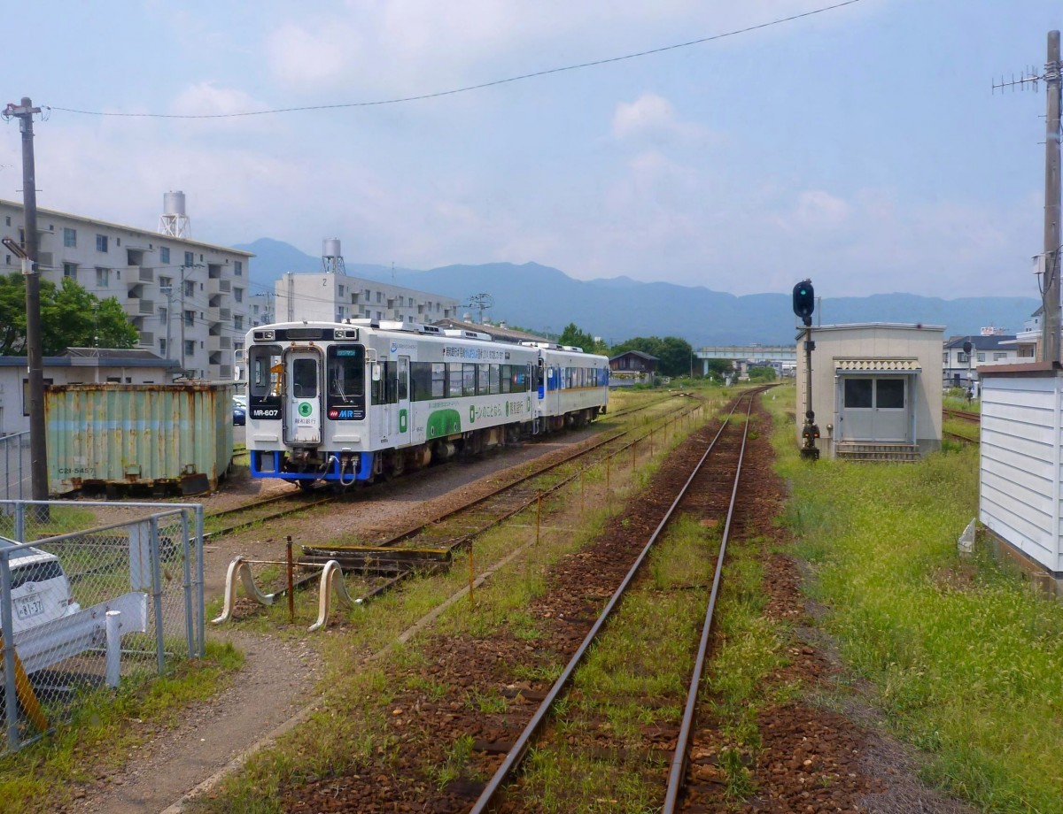 Matsuura-Bahn: In Imari kommen die lange Linie aus Sasebo an der Westküste (80,8 km) und die kürzere Linie durch die Berge von Arita her (13 km) zusammen. Bild: Wagen 607 (mit Werbung für eine Ladenkette) und 605, Imari, 7.August 2013. 