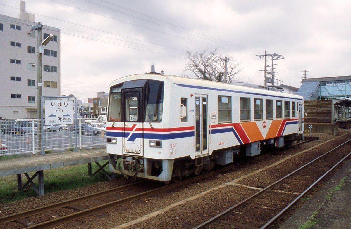 Matsuura-Bahn, die Originalwagen von 1988 (Nr.101-111) und 1989-1992 (Nr. 121-126). Diese Wagen sind alle bis 2012 ausgeschieden; Nr.111, der Wagen im Bild, fährt heute als Nr.2577 in Myanmar. Im Hintergrund ist die nach 1988 errichtete Trennwand zu sehen zwischen der nun privaten Matsuura-Bahn und der JR-Linie; heute steht hier ein grosses Informationszentrum für Touristen. Imari Endstation, 25.März 1999. 