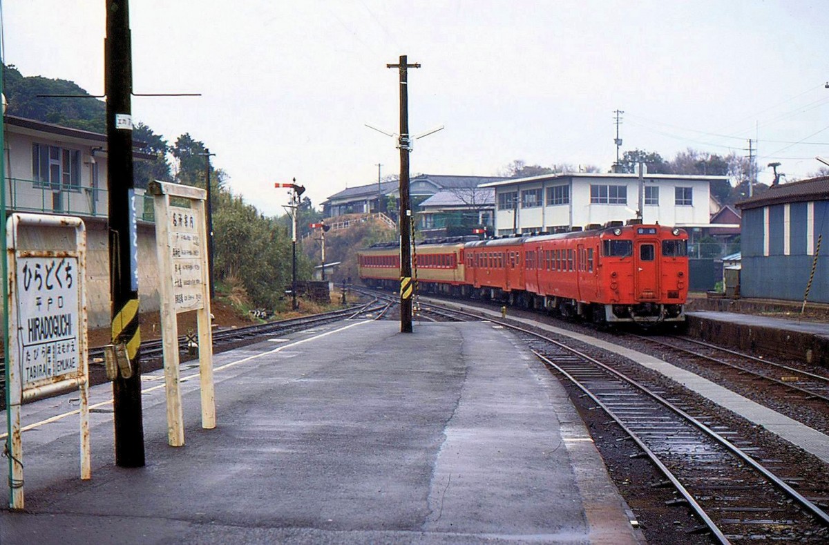 Matsuura-Bahn, Tabira Hiradoguchi, Japans westlichste Bahnstation, Blick nach Süden: Am 19.März 1981 befährt die alte Staatsbahn die Linie noch mit bunt zusammengewürfelten Vierwagenzügen. Im Bild Ausfahrt des Zuges mit zwei Schnellzugstriebwagen KIHA 58 (Nr. 145 und 139), einem Lokalverkehrswagen mit entlang der Seitenwand angeordneten Türen KIHA 20 201 (KIHA 20: 409 Wagen gebaut 1957-1965) und am Schluss einem neueren Wagen mit entlang der Seitenwand angeordneten Türen KIHA 47 1079 (KIHA 47: 370 Wagen gebaut 1977-1982). MATSUURA-LINIE 