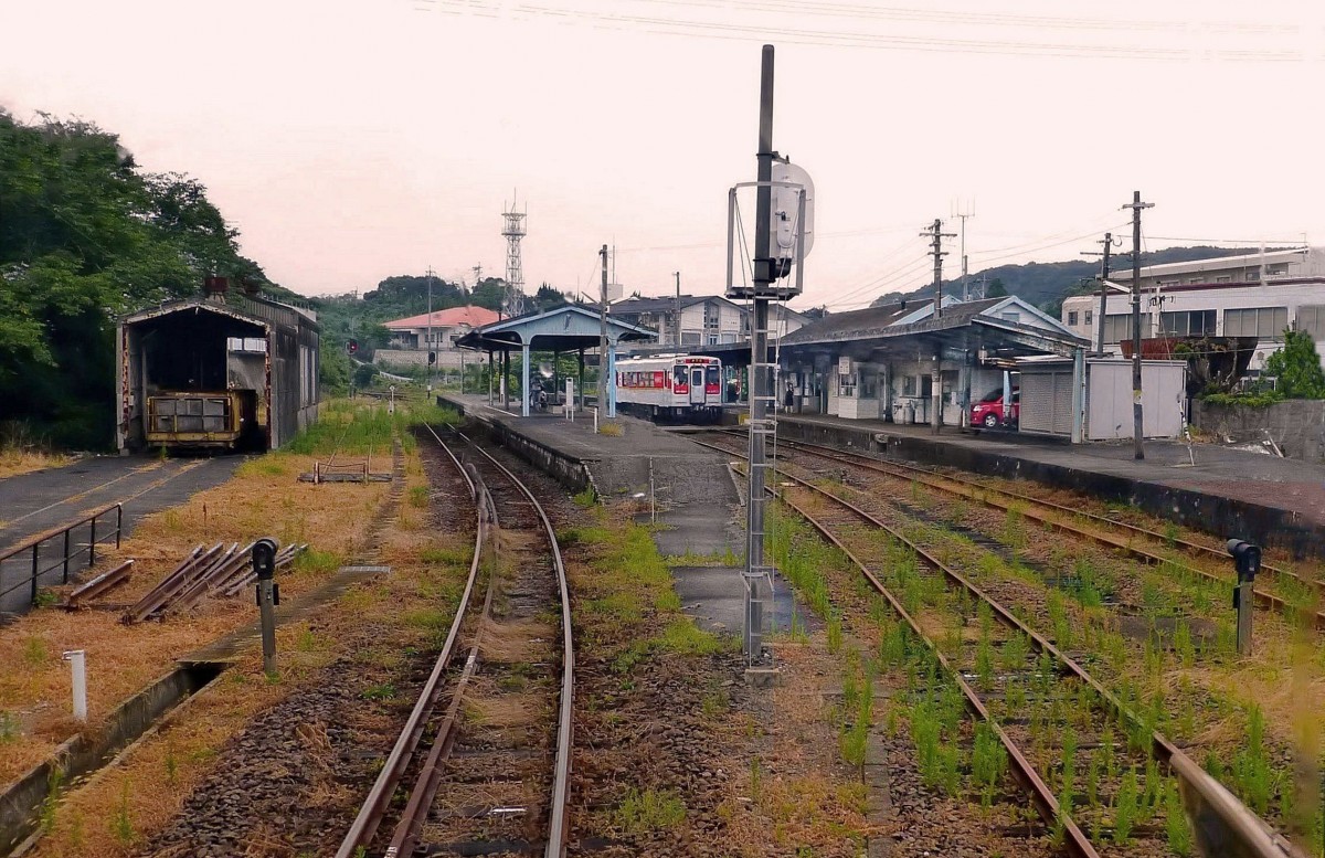 Matsuura-Bahn, Tabira Hiradoguchi, Japans westlichste Bahnstation, Blick nach Süden: Heute genügt ein Einzeltriebwagen (im Bild Wagen 620), um an diese historische Stätte zu kommen, wo sich auf der Insel unterhalb der Bahnstation im 16.Jahrhundert ein grosses Asien-Handelszentrum mit Portugiesen, Engländern, Holländern, Chinesen etc. befand, bis sich Japan 1641 der Aussenwelt verschloss. Gegenüber dem Bild vom 19.März 1981 sind die grossen alten Häuser im Hintergrund verschwunden, und Lichtsignale sind aufgestellt; die ganze Landschaft wirkt irgendwie öde. 26.Juli 2013. 