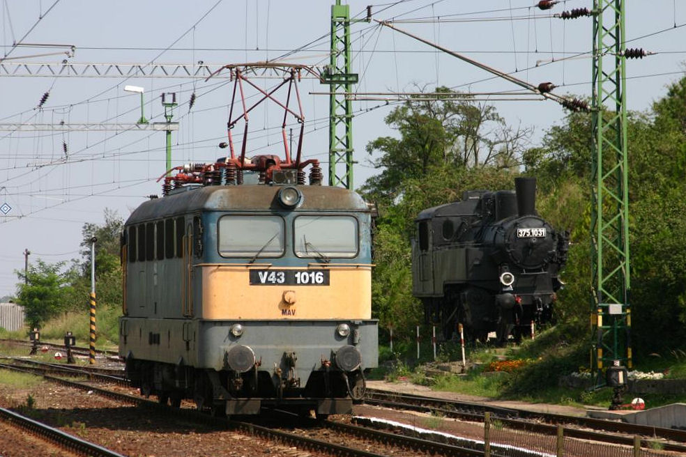 MAV Elektrolok V 431016 fährt im Bahnhof Veszprem am 2.9.2005 an dem
neben den Gleisen leicht erhöht stehenden Dampflok Denkmal der 3751931 vorbei.