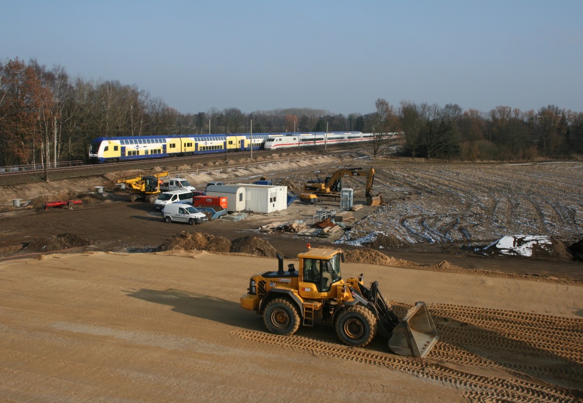 ME 82122 (Uelzen–Hamburg Hbf) und ICE 79 (Hamburg-Altona–Zrich HB) passieren am 14.02.2013 die Baustelle zur Neuerrichtung einer Straenbrcke zwischen Winsen (Luhe) und Ashausen.