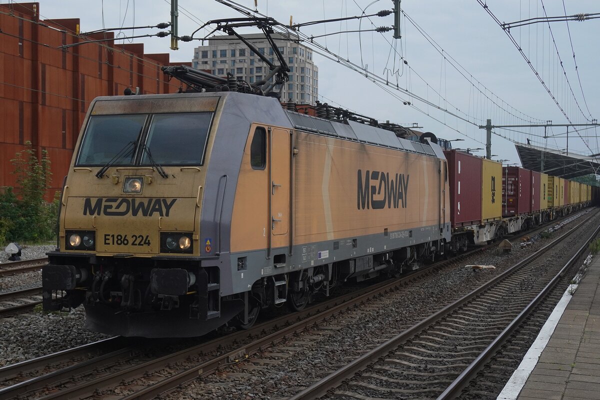 Medway 186 224 zieht der Neuss-Shuttle Containerzug nach Antwerper Hafenrevier durch Tilburg am 8 Mai 2026. Das rostbraune Geb�ude im Hintergrund ist eine neue PKW Parking Garage.