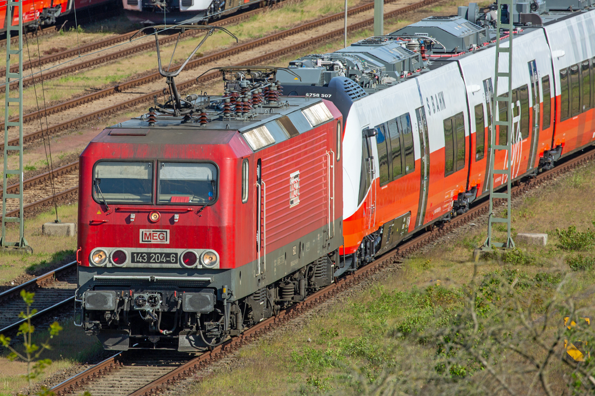 MEG Lok 143 204 mit Scharfenbergkupplung wurde vor Talent 3 Triebwagen gesetzt. Sicht von der L 29 auf den Mukraner Fährhafen. - 23.05.2022