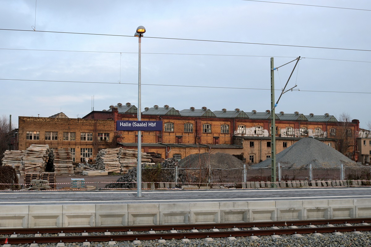 Mehrere Gebäude des ehemaligen RAW Halle (Saale) auf dem Gebiet der DR, so wie dieses neben dem Hauptbahnhof, bleiben noch erhalten und bilden ein großflächiges Industriedenkmal. So kann man sagen, dass die Gegend sich zu einem verwunschenen Ort entwickelt hat.
Aufgenommen von Bahnsteig 10/11. [2.12.2017 | 15:20 Uhr]