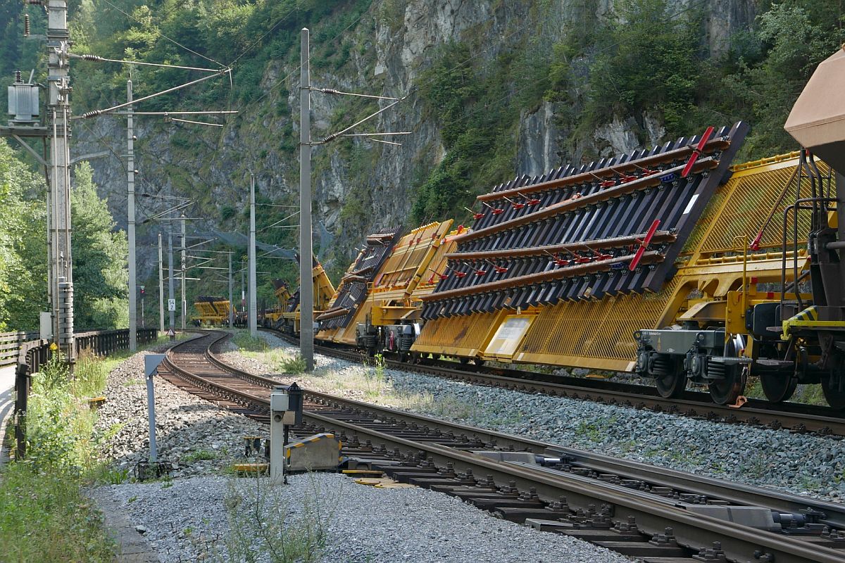 Mehrere Weichentransportwagen und drei Flachwagen sind im Inntal auf der wegen Bauarbeiten gesperrten Arlbergbahn in der Nähe des Bahnhofs Imst-Pitztal abgestellt (18.08.2018).