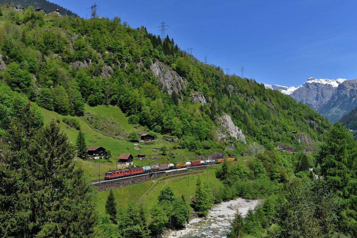 Mein 5000. Bild auf Bahnbilder zeigt eine Aufnahme aus eines der schönsten Bahnstrecken Europas, der Gotthardbahn. Eine Aufnahme, die bald historisch sein wird, da bereits am 01.06.2016 der aktuell längste Bahntunnel der Welt, der Gotthard Basistunnel, mit einer Länge von 57,1 km, eröffnet wurde. Ab dem Fahrplanwechsel im Dezember werden ein Großteil des Güterverkehrs sowie der Personenverkehr durch den Tunnel fahren, der in Nord-Süd-Richtung in Erstfeld im Kanton Uri beginnt und in Bodio im Tessin endet.  Grund genug für mich, noch einige Aufnahmen von dieser Motivreichen Strecke zu machen. Am 21.05.2016 war es wieder einmal soweit: ein Gotthardbesuch stand an. Fehlende Motive abgeklappert, und dazu den Dampfzug als Gotthard-Abschiedsfahrt. Zeigen möchte ich hier allerdings nicht den Sonderzug, sondern einen klassischen KLV-Zug mit einer Re 10/10, die hier bei Gurtnellen auf dem Weg in den Süden sind. 
