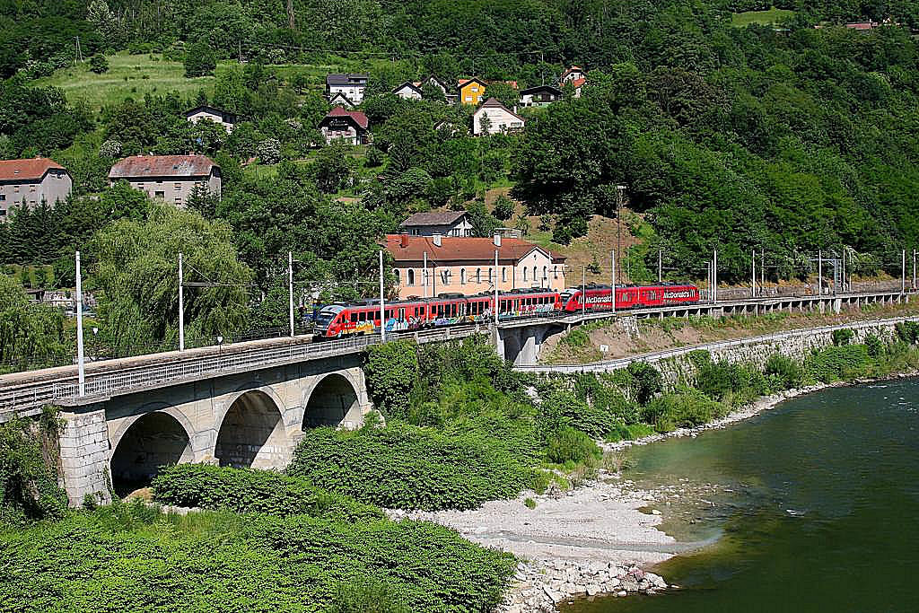 Mein Liebling Fotopunkt in Slowenien: Bahnhof Hrastnik an der Save gelegen. Von der Straßenbrücke aus bietet sich dieses Bild auf eine Steinbogenbrücke, wo ein Zufluss der Save einmündet, und den darüber liegenden Bahnhof. Im Bahnhof zweigt in Blickrichtung unterhalb auch noch ein Industriegleis ein, welches nahezu täglich bedient wird. Der Bahnhof selbst ist Haltestelle für die Nahverkehrszüge. Auf dem Foto ist eine Doppeleinheit Desiros der Reihe 312 zu sehen, der in Richtung Lubljana unterwegs ist. Das zweite Fahrzeug ist auch ein mit Mc Donald Werbung versehener Triebwagen. Die Aufnahme entstand am 24.5.2011.
