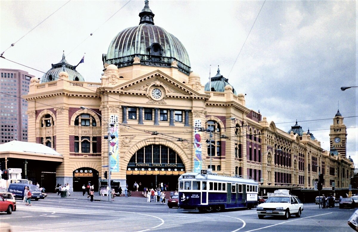 Melbourne Flinders Street Station, Farbnegativscan vom März 1996
Das Empfangsgebäude liegt an der Ecke der Flinders Street und Swanston Street, die Rückseite der Bahnanlagen bildet der Yarra River.