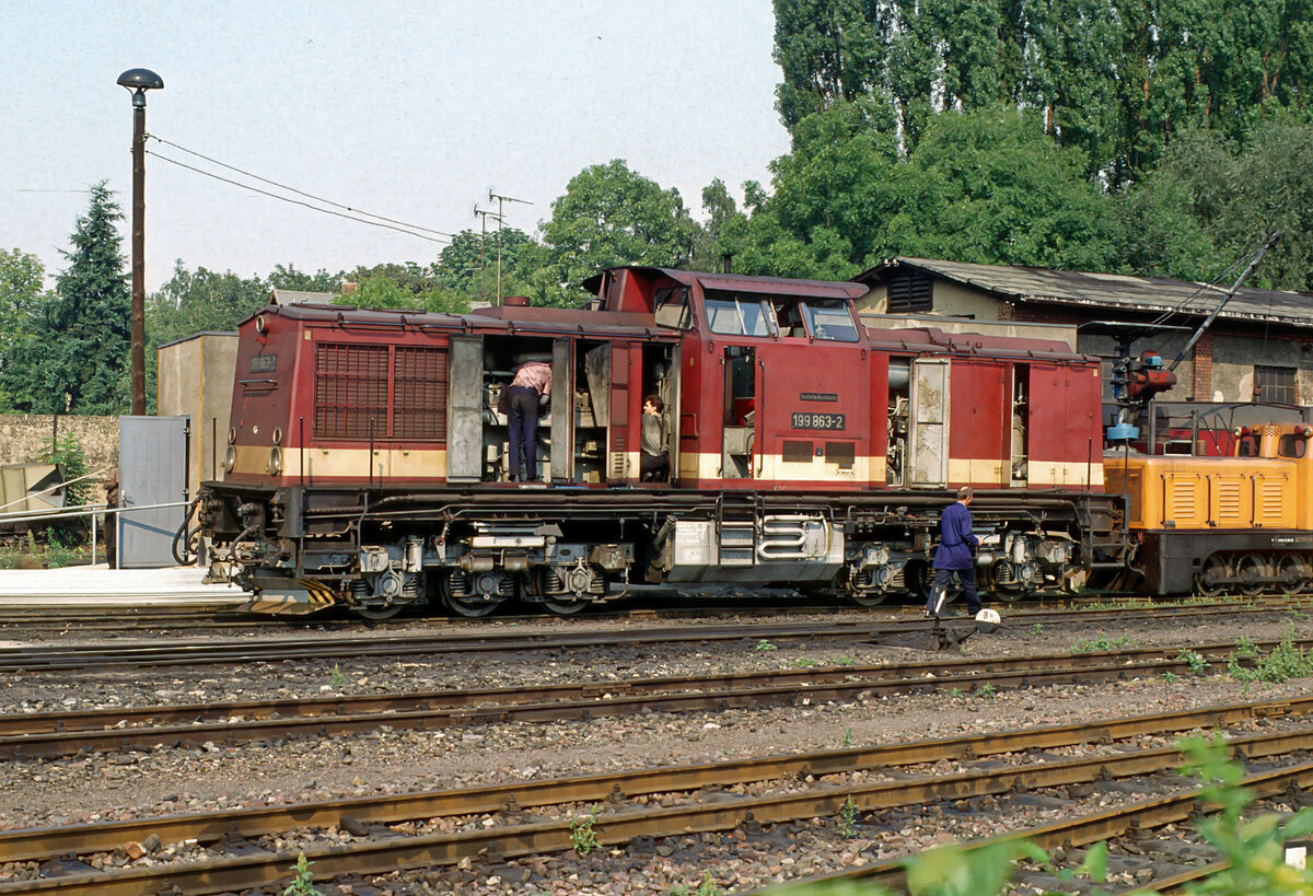  Men at work : DR-Mitarbeier sind am 08.04.1991 im Bw. Wernigerode-Westerntor mit Arbeiten an der Schmalspurdiesellok 199 863 beschäftigt.