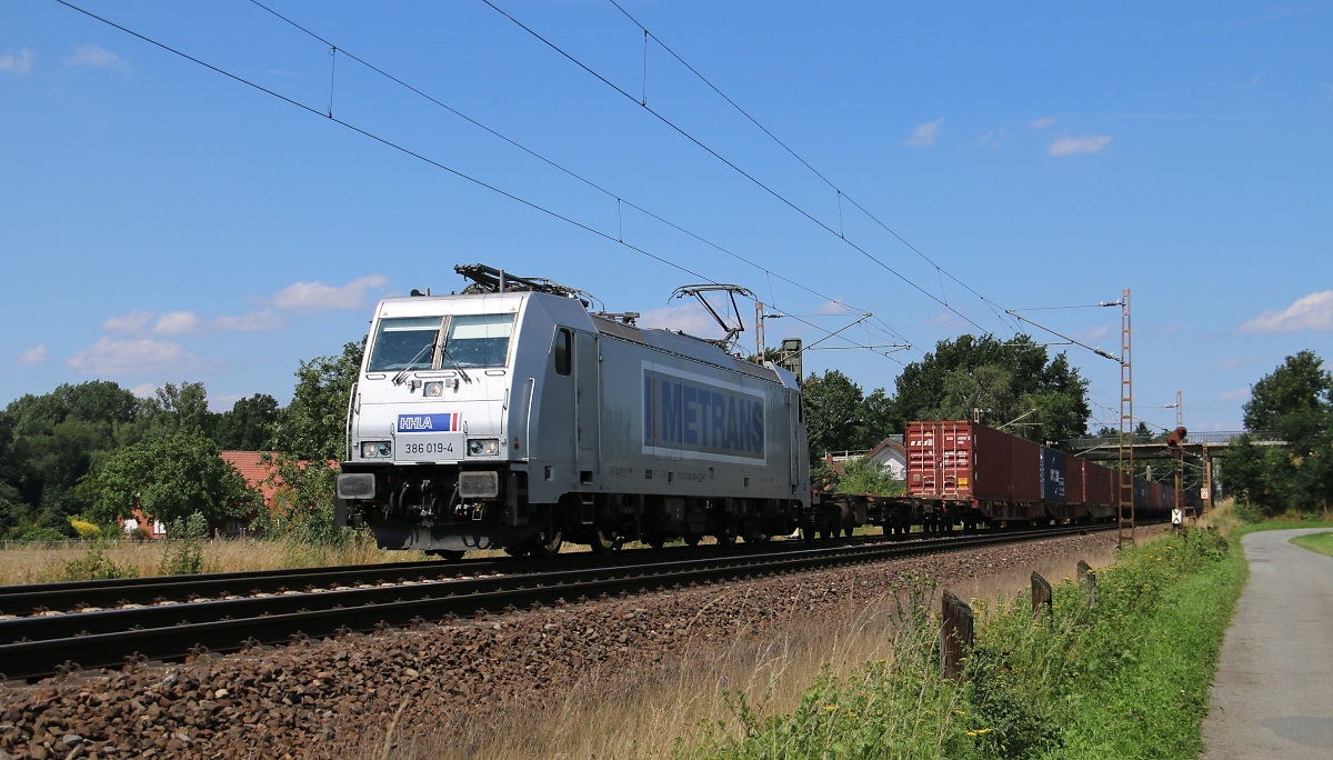Metrans 386 019-4 mit Containerzug in Fahrtrichtung Nienburg(Weser). Aufgenommen am 22.07.2015 in Eystrup.