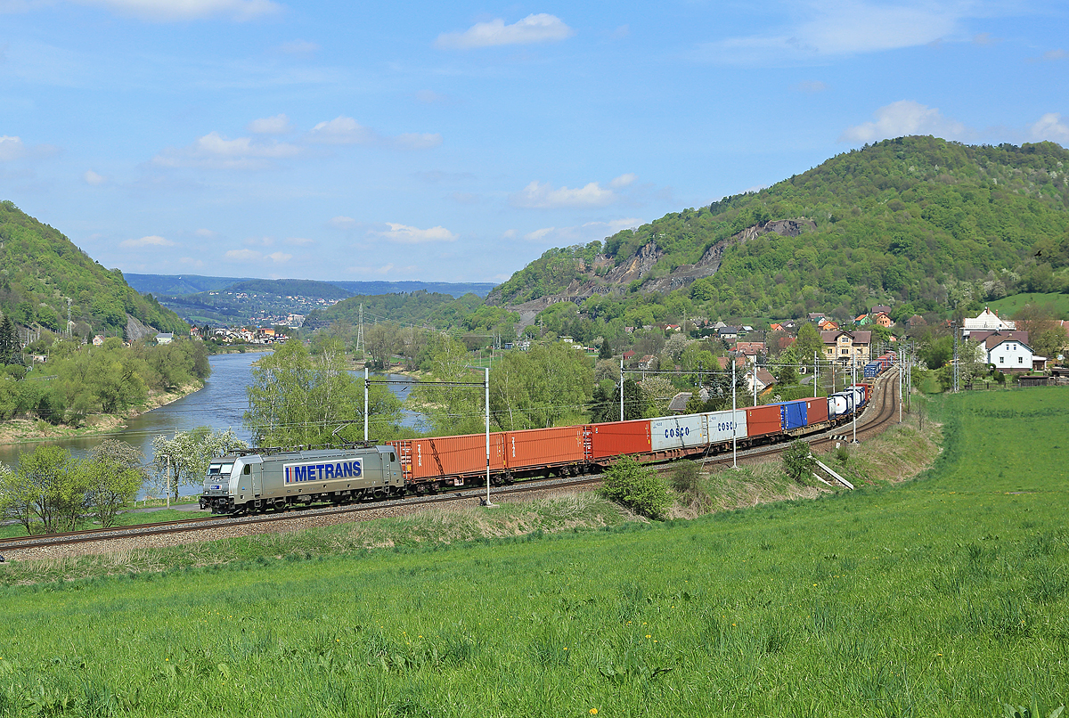 Metrans 386006 hauls a southbound intermodal train along the east bank of the River Elbe, pictured here passing the village of Techlovice, 29 April 2015