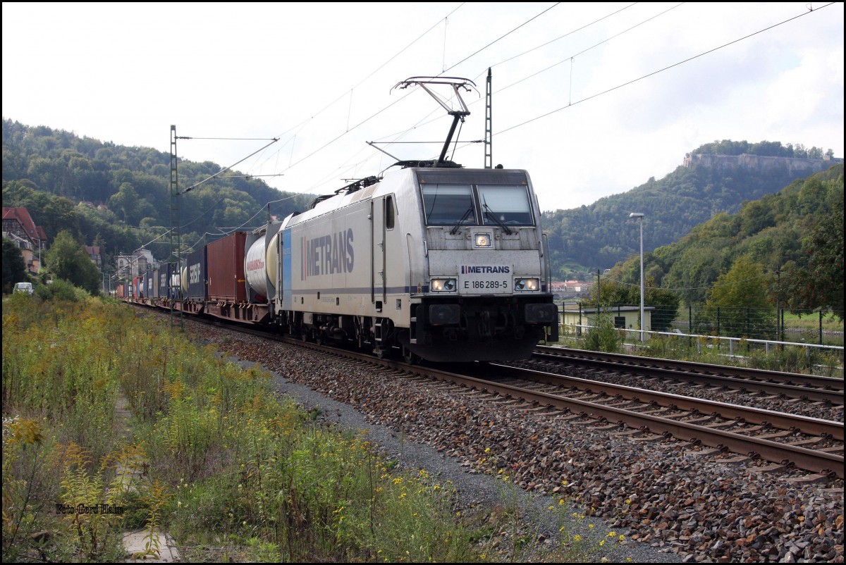 Metrans E 186289 war am 24.09.2015 um 13.19 Uhr bei Königstein mit einem Container Zug in Richtung Tschechien auf der Elbtalbahn unterwegs. Im Hintergrund kann man im leichten Gegenlicht die Festung Königstein erkennen.