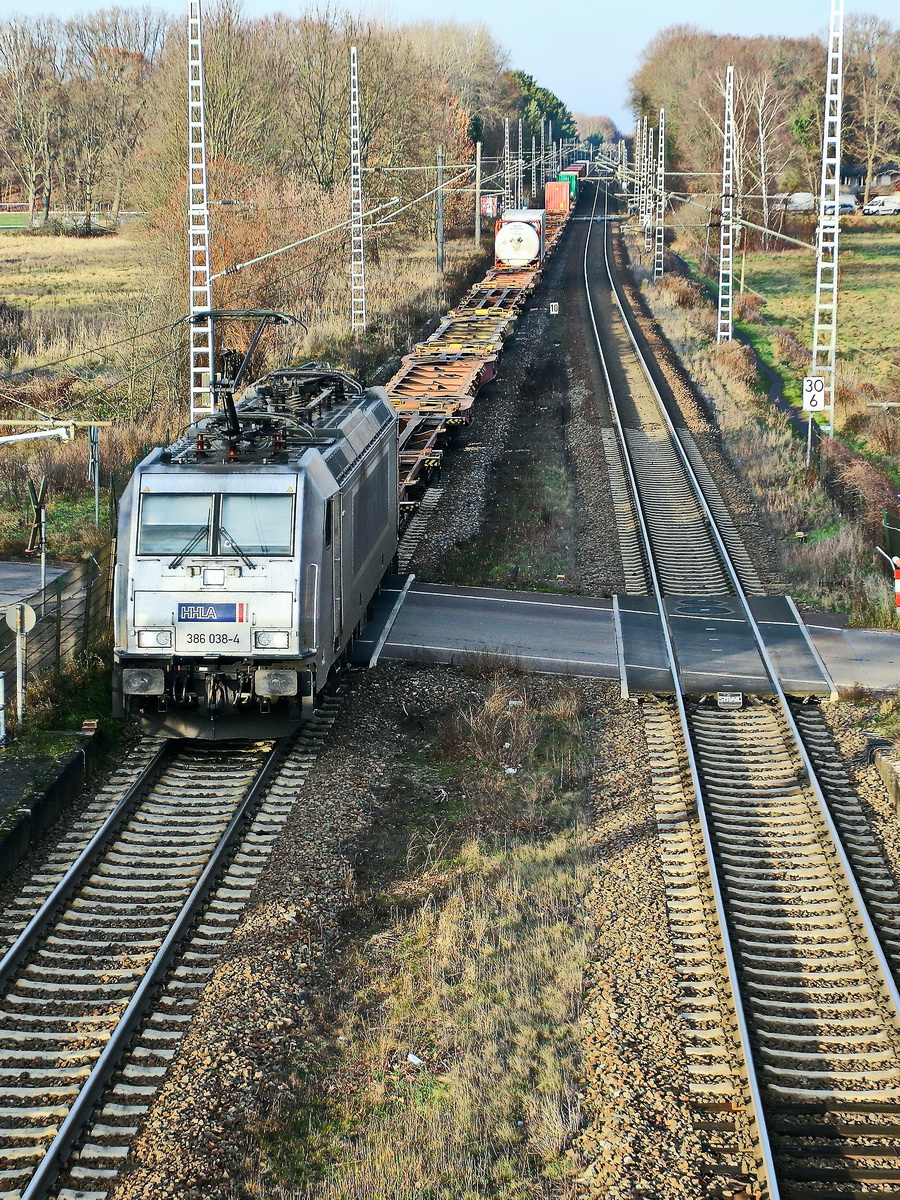 METRANS Rail s.r.o., Praha [CZ] mit 386 038-4 (NVR-Nummer: 91 54 7386 038-4 CZ) und Containerzug am 22. Dezember 2021 am Bahnübergang am Bahnhof Dabendorf in Brandenburg.