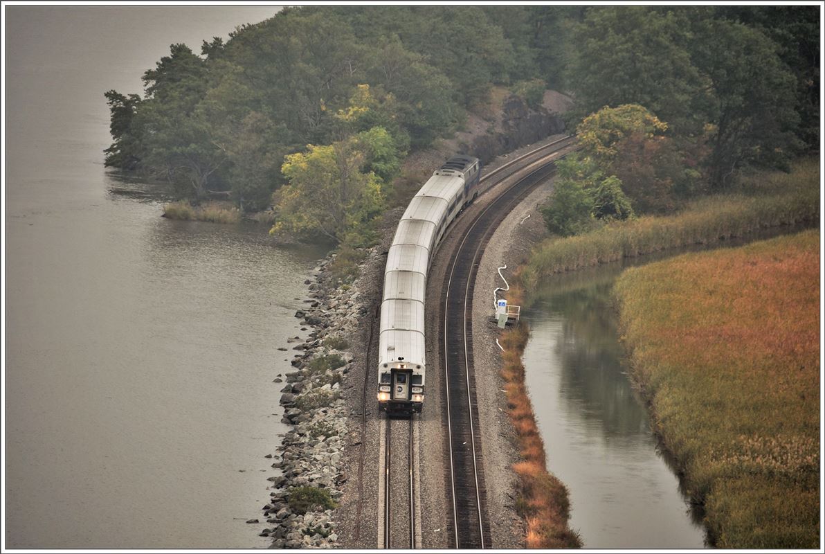 Metro North Zug der Hudson Line nach New York Grand Central Station fährt dem Hudson entlang und unterquert die Bear Mountain Hängebrücke bei Peekskill (07.10.2017)