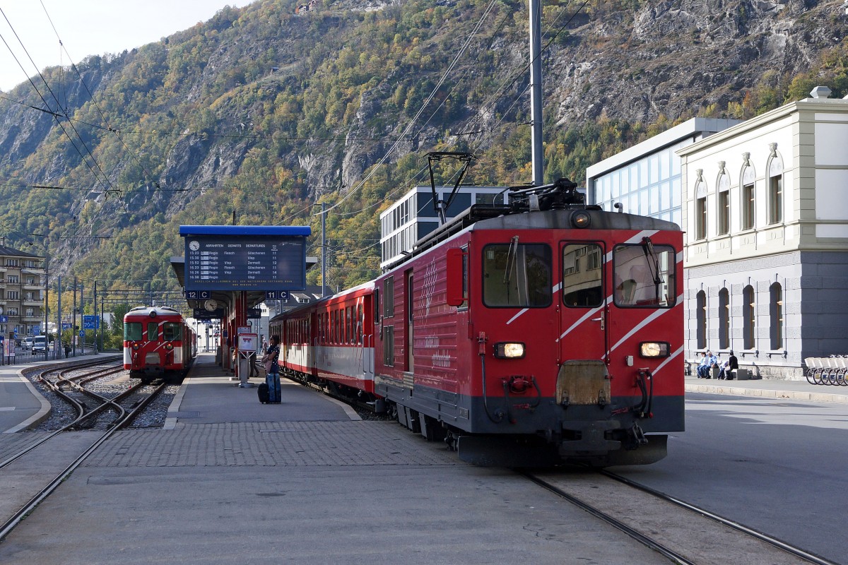 MGB: Matterhorn-Gotthard-Bahn als Zahnrad-, Regional- sowie Strassenbahn in Einem. Bei der Ueberquerung des Bahnhofplatzes Brig ist der Regionalzug Visp-Brig-Fiesch-Andermatt-Gschenen mit dem Deh 4/4 ll 93 auf einem kurzen Streckenabschnitt als Strassenbahn unterwegs. Die Aufnahme ist am 25. Oktober 2013 entstanden.
Foto: Walter Ruetsch