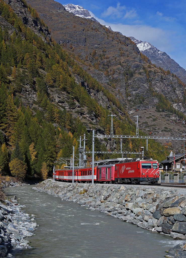 MGB: Regio mit HGe 4/4 ll 2 bei der Ausfahrt Tsch in Richtung Zermatt am 25. Oktober 2013. Etwas speziell ist der mitgefhrte Gepckwagen, noch immer mit altem Anstrich, eingereiht hinter der Lok.
Foto: Walter Ruetsch