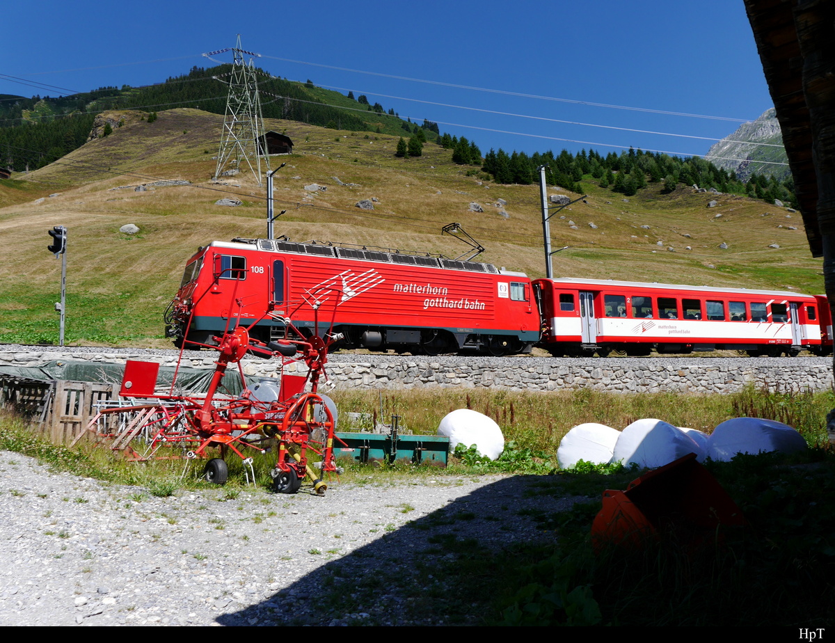 MGB - Schnappschuss der Zahnradlok HGe 4/4  108 mit Regio unterwegs bei Sedrun am 27.07.2018