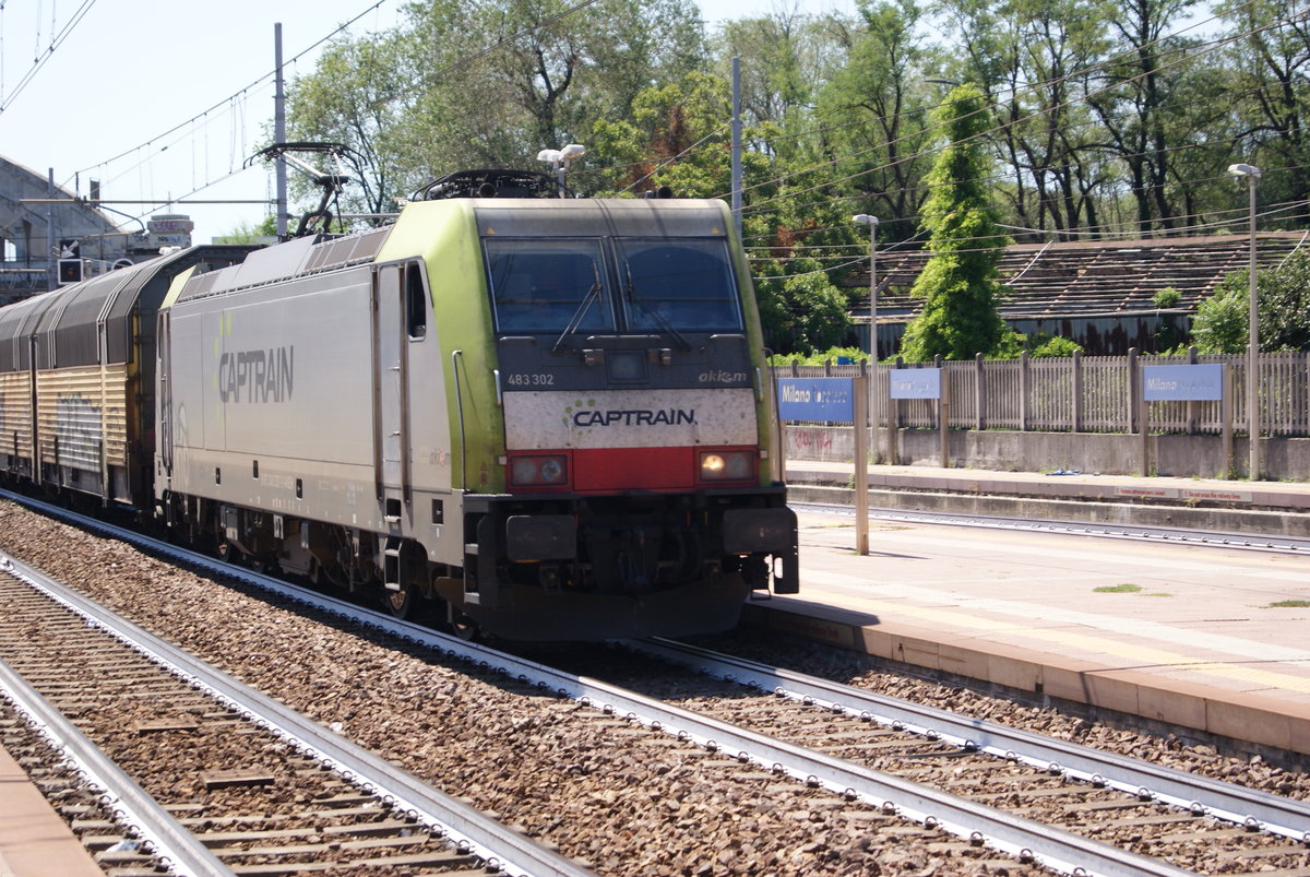 milano rogoredo station 29 lug 2019 : e lok Captrain e 483.302 in transit at Milano Rogoredo station with a train of vehicles