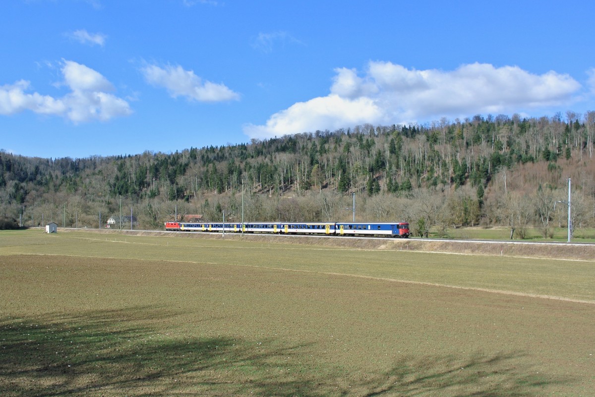 Militrextrazug Bure (Extrabahnhof/Linie frs Militr) - Delmont - Laufen - Basel SBB kurz vor Porrentruy. Bei diesem Pendel handelt es sich um einen HVZ Einschaltpendel der S-Bahn Basel. Da die EWI/II Einschaltpendel tagsber normalerweise abgestellt sind, werden diese gerne fr die Militrtransporte verwendet. Im Bild ist der BDt EWI 50 85 82-33 976-0, AB EWII 008-4, 3 B EWI und Re 4/4 II 11219, 05.03.2015.