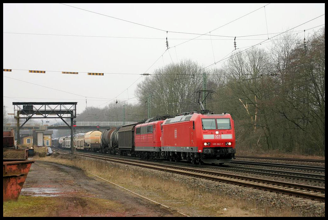 Mit einer 151 im Schlepp kommt hier die DB  185062 am 18.03.2006 mit einem Güterzug in Richtung Osnabrück fahrend durch den Bahnhof Natrup Hagen.