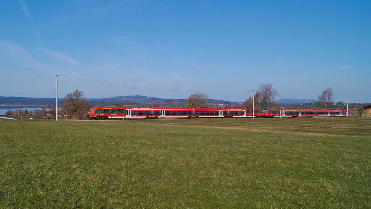 Mit Aussicht auf den Staffelsee näherte sich eine Doppeltraktion 2 442 am 25.03.2018 dem Bahnhof von Murnau in Richtung Garmisch-Partenkirchen. 