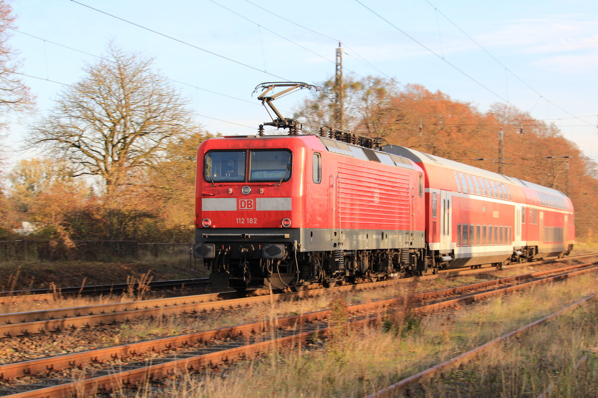 Mit beraubten KWS Dosen und mit DSA 200 Stromabnehmer kommt die 112 182 recht sportlich daher. Im Bahnhof Miltzow gelang mir ein kleiner Mitzieher an besagter Lok, schiebend am RE7 Stralsund Hbf - Greifswald (10.11.2021).