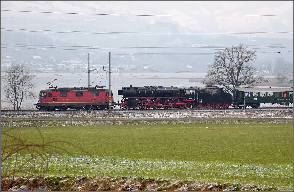 Mit Dampf zum Gotthard. Blindenhund Re 4/4 II 11325 voraus wird 01 202 mit ihrem Sonderzug zur Bergstrecke gebracht. Seewen, März 2018.