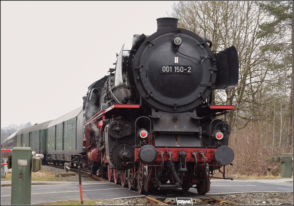 Mit Dampf zum Gotthard. Heute fahren auch Dampfloks als Pendelzug, die Strecke von Hergatz bis Kisslegg muss 01 150 schieben, denn eine Baustelle verwehrte den Weg über Lindau nach Singen. Kisslegg, März 2018
Nachtrag: Fotostandort hinter Absperrgitter.