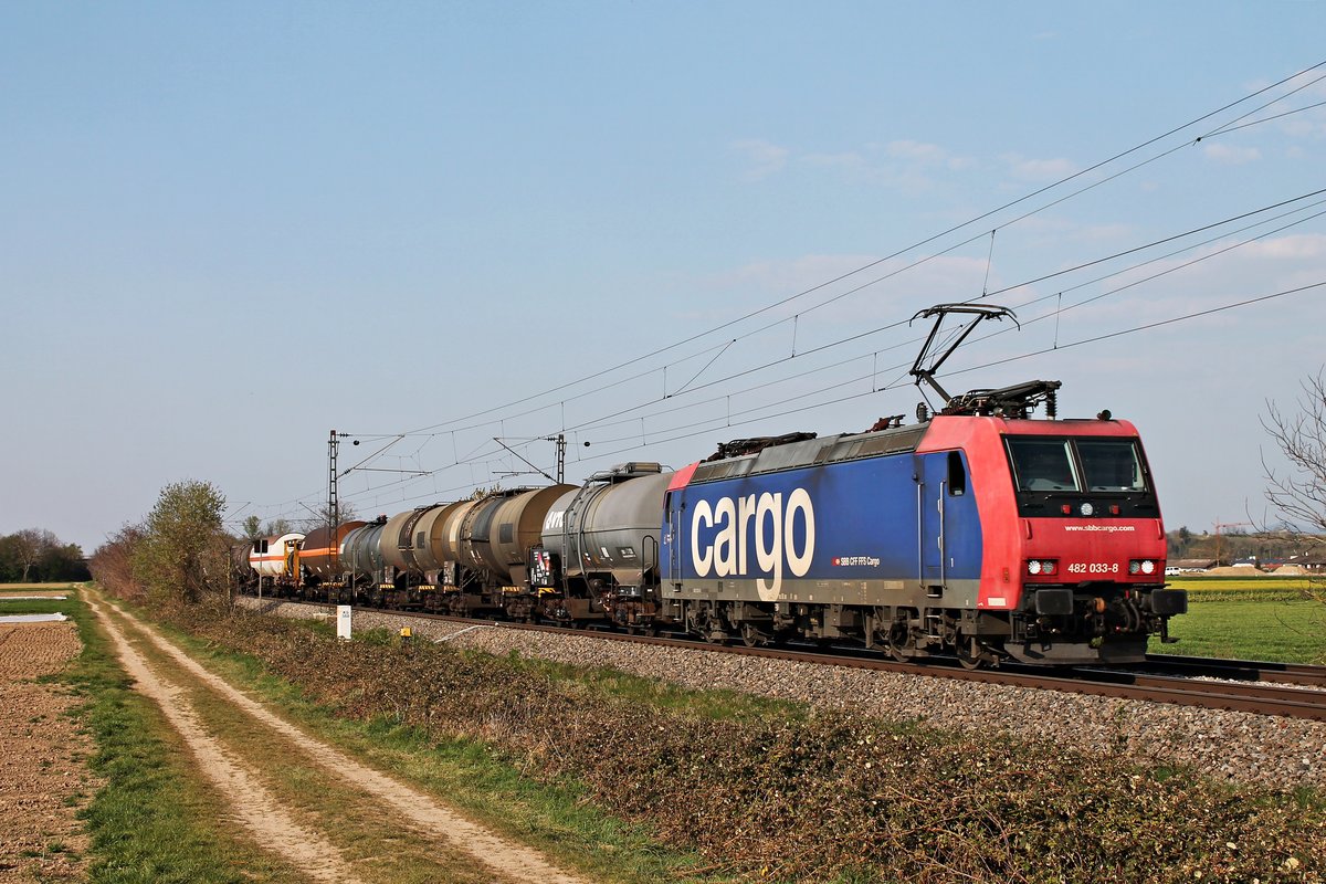 Mit dem  BASF -Zug DGS 49069 (Karlsruhe Gbf - Basel SBB RB) fuhr am frühen Abend des 09.04.2020 die Re 482 033-8  Basler Rheinhäfen  südlich von Buggingen über die KBS 702 durchs Markgräflerland in Richtung Schweiz.
