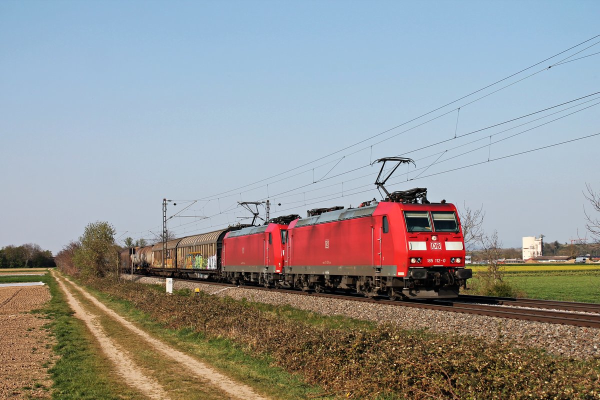 Mit dem EZ 45023 (Mannheim Rbf - Chiasso Smistamento) fuhr am Nachmittag des 10.04.2020 die 185 112-0 zusammen mit der 185 089-0 südlich von Buggingen über die KBS 702 durchs Rheintal in Richtung Schweiz.