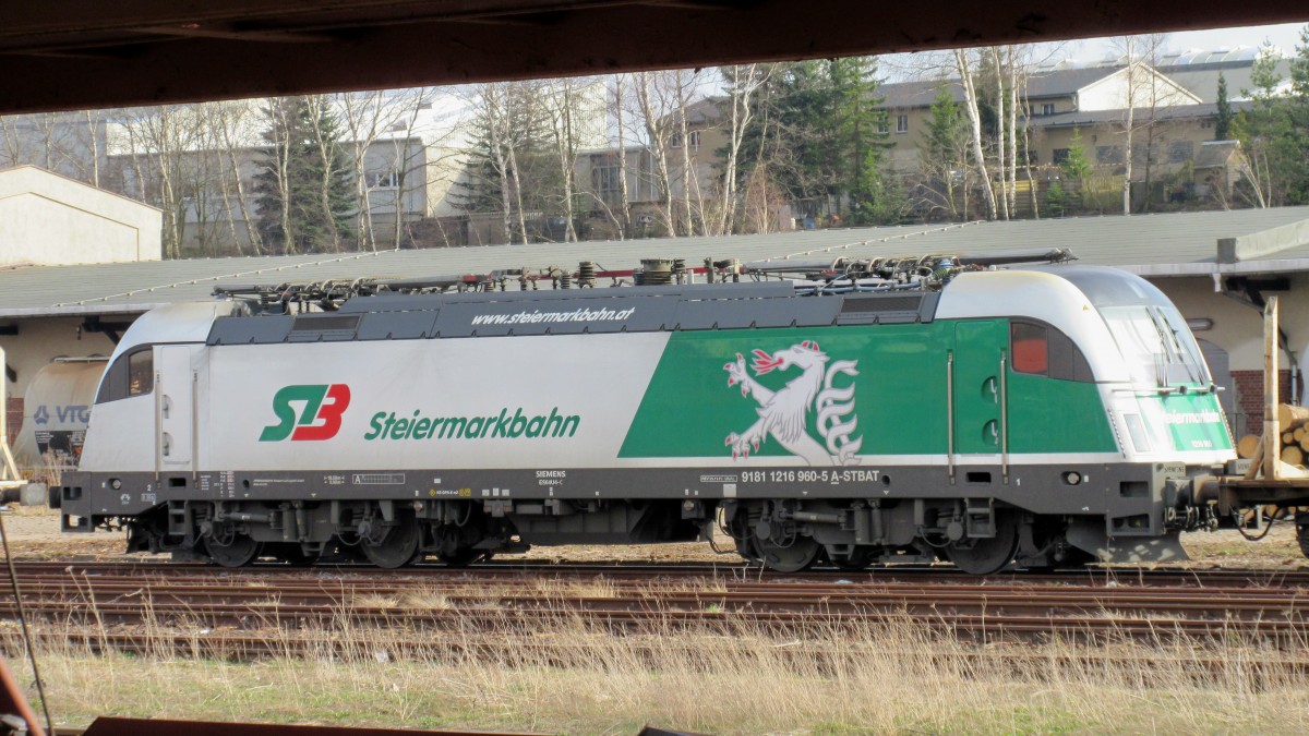 mit dem ganzem Holzumschlag am Bahnhof Freiberg kommen jetzt ab und zu mal  Exoten  und da war diese Woche die 1216 960-5 der Steiermarkbahn aus Österreich zu Gast, die einen leeren Holzzug brachte und am nächten Tag wieder mitnahm. Fotografiert vom Bahnsteig aus durch abgestellte Autotransportwaggons (14.4.15)  
