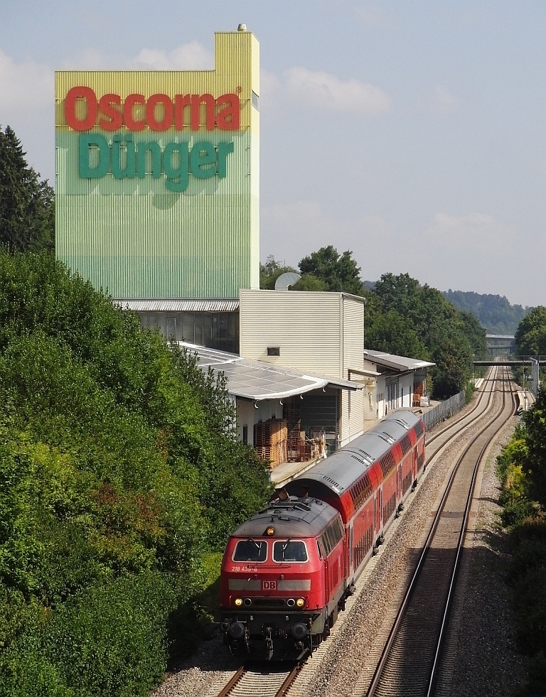 Mit dem IRE 4209 von Ulm nach Lindau fährt 218 439-8 am 21.08.2013 am Industriegebiet Ulm-Donautal vorbei. Im Hintergrund ist die gleichlautende Haltestelle zu sehen.
